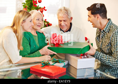 Man giving gift à ses hauts mère à la veille de Noël Banque D'Images