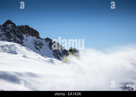 Motion shot de poudreuse avec lever du soleil et ciel bleu sur l'arrière-plan Banque D'Images