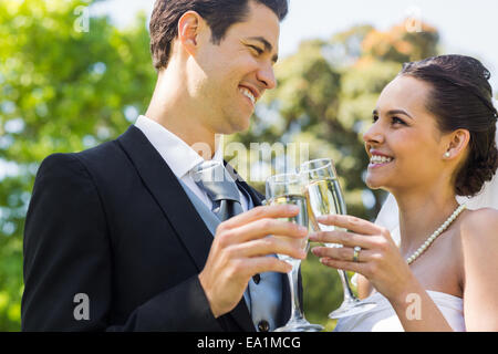 Newlywed toasting champagne flutes at park Banque D'Images