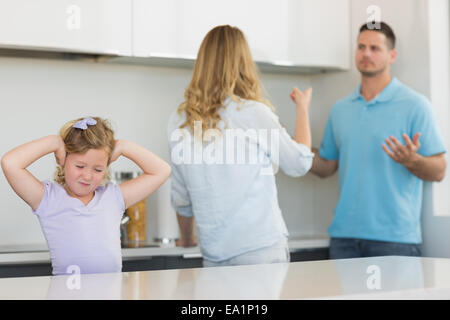 Girl couvrant les oreilles tout en soutenant les parents Banque D'Images