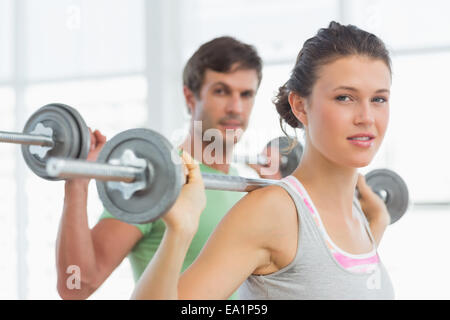 Mettre en place des barres de levage young couple in gym Banque D'Images