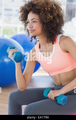 Young woman exercising with dumbbells in gym Banque D'Images