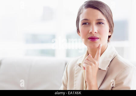 Penser businesswoman sitting on sofa Banque D'Images