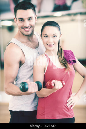 Deux smiling people working out with dumbbells Banque D'Images