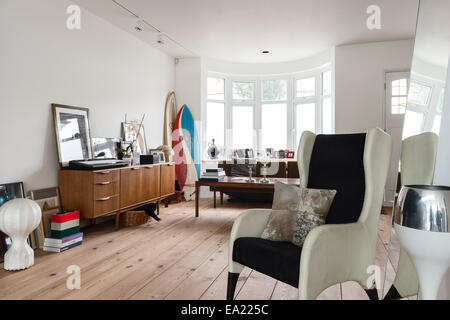 Fauteuil wingback moderne dans un espace de vie lumineux et spacieux avec du parquet et des planches dans le coin Banque D'Images