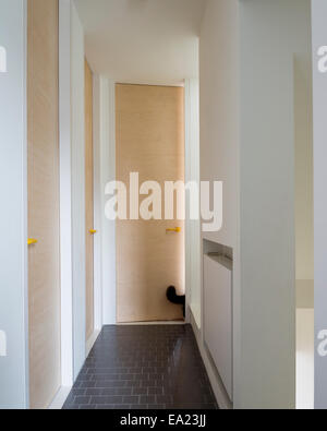 Carrelage dans le couloir avec portes en bois et des poignées jaunes Banque D'Images