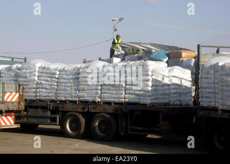 Rafah, bande de Gaza, territoire palestinien. 5Th Nov, 2014. Un travailleur palestinien supprime le cache en plastique sur un sommet d'un camion chargé de fournitures qui sont entrés dans la bande de Gaza d'Israël par le terminal de Kerem Shalom à Rafah dans le sud de la bande de Gaza le 5 novembre 2014. Envoyé spécial de la paix de l'ONU Robert Serry a annoncé le 4 novembre que le mécanisme de reconstruction temporaire pour le territoire palestinien a commencé ses activités, sous les auspices du nouveau gouvernement palestinien d'union nationale, notant l'urgence dans la fourniture de ciment et autres matériaux à des dizaines de milliers de maisons endommagées Banque D'Images