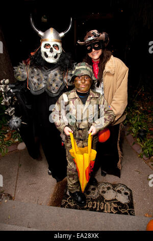 La famille en costume de trick or treating le soir de l'Halloween. St Paul Minnesota MN USA Banque D'Images