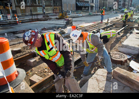 Detroit, Michigan - Travailleurs installer rails pour 3,3 milles M1 projet ferroviaire. Banque D'Images