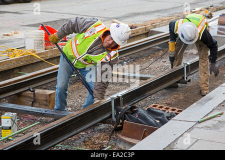 Detroit, Michigan - Travailleurs installer rails pour 3,3 milles M1 projet ferroviaire. Banque D'Images