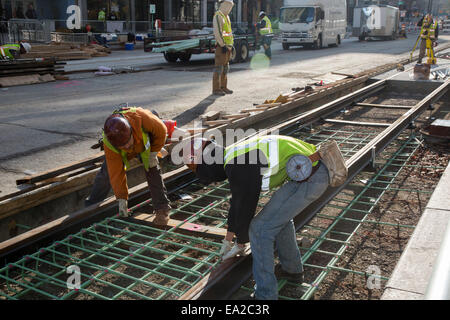 Detroit, Michigan - Travailleurs installer rails pour 3,3 milles M1 projet ferroviaire. Banque D'Images