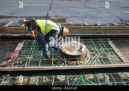 Detroit, Michigan - Travailleurs installer rails pour 3,3 milles M1 projet ferroviaire. Banque D'Images