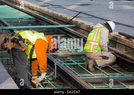 Detroit, Michigan - Travailleurs installer rails pour 3,3 milles M1 projet ferroviaire. Banque D'Images