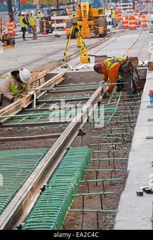 Detroit, Michigan - Travailleurs installer rails pour 3,3 milles M1 projet ferroviaire. Banque D'Images