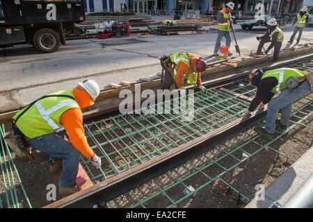 Detroit, Michigan - Travailleurs installer rails pour 3,3 milles M1 projet ferroviaire. Banque D'Images