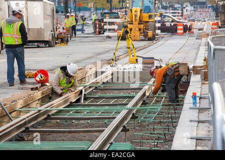 Detroit, Michigan - Travailleurs installer rails pour 3,3 milles M1 projet ferroviaire. Banque D'Images