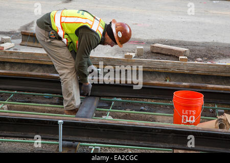 Detroit, Michigan - Travailleurs installer rails pour 3,3 milles M1 projet ferroviaire. Banque D'Images