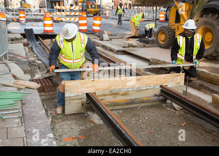 Detroit, Michigan - Travailleurs installer rails pour 3,3 milles M1 projet ferroviaire. Banque D'Images