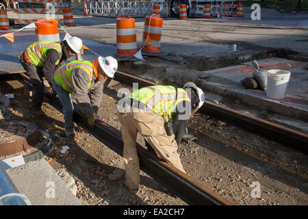 Detroit, Michigan - Travailleurs installer rails pour 3,3 milles M1 projet ferroviaire. Banque D'Images