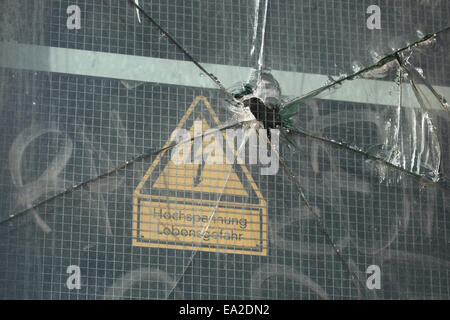 Du verre brisé sur un boîtier électrique avec un signe de haute tension à Dresde, Saxe, Allemagne. Banque D'Images