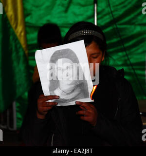 LA PAZ, BOLIVIE, 5 novembre 2014. Une fille met le feu au portrait de l'un des étudiants disparus lors d'une représentation d'une troupe de théâtre lors d'un événement organisé pour montrer sa solidarité avec les 43 étudiants disparus au Mexique et exiger leur libération en toute sécurité. Les étudiants (qui venaient d'un collège de formation des enseignants à Ayotzinapa) ont disparu après des affrontements avec la police dans la nuit du 26 septembre dans la ville d'Iguala dans l'Etat de Guerrero. Banque D'Images