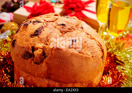 Libre d'un panettone, un doux italien typique pour la période de Noël, sur une table avec champagne et cadeaux Banque D'Images