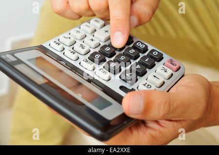 Libre d'un jeune homme dans des vêtements à l'aide d'une calculatrice Banque D'Images