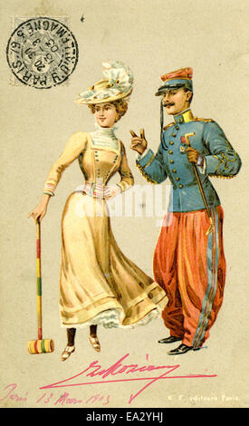 Cette carte postale vintage représente un homme et une femme jouant au croquet, une activité de loisirs populaire à la fin du XIXe et au début du XXe siècle. L'image capture la nature détendue du jeu, situé dans un environnement extérieur luxuriant typique de l'époque. Banque D'Images