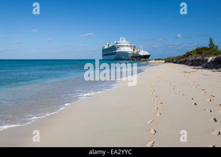 Empreintes de pas sur une plage de sable blanc avec deux navires de croisière amarré dans une mer turquoise, Grand Turk, Turks et Caicos, West Indies Banque D'Images
