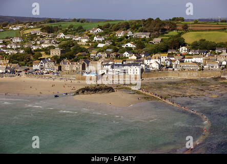 Les personnes qui traversent la chaussée à partir de la marée Mont St. Michaels à Marazion à marée montante, Cornwall, Angleterre, Royaume-Uni Banque D'Images