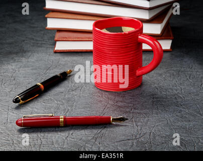 Stylos avec une tasse de café et les organisateurs Banque D'Images