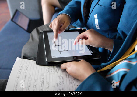 Les élèves de l'enseignement secondaire à l'aide de tablette ordinateur écran tactile pour apprendre à écrire des caractères chinois, mandarin. Banque D'Images