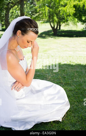 Femme bride sitting on grass in park Banque D'Images