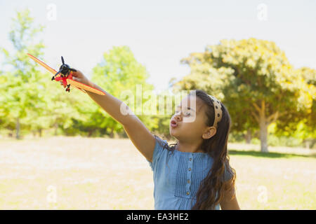 Fille jouant avec un jouet avion à park Banque D'Images