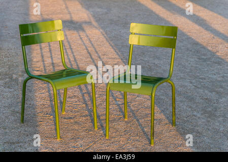 Deux chaises vertes côte à côte dans le soleil du soir dans le jardin des Tuileries, Paris, France. Banque D'Images