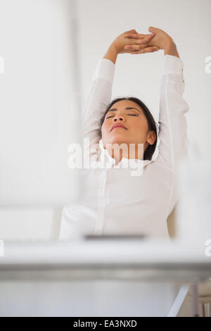 Femme d'occasionnels la sieste à son bureau Banque D'Images