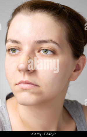 Jeune femme avec pansement sur son nez Banque D'Images