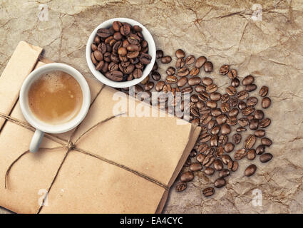 Tho petites tasses à café blanc pleins d'espresso et de fèves torréfiées, vue du dessus sur l'ancienne table avec nappe et de pape fermé Banque D'Images