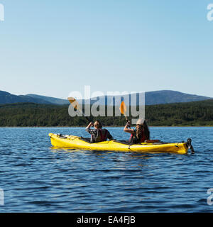 Deux jeunes femmes kayak dans le parc national du Gros-Morne, Trout River, Newfoundland, Canada Banque D'Images