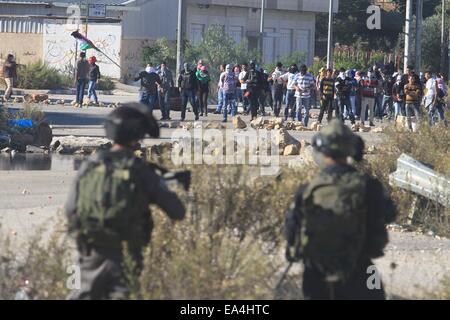 (141106) -- RAMALLAH, le 6 novembre 2014 (Xinhua) -- des étudiants palestiniens en conflit avec des soldats israéliens à l'extérieur de la prison d'Ofer près de la ville de Ramallah, en Cisjordanie comme ils protestent contre les restrictions à l'entrée récente de la vieille ville de Jérusalem, le 6 novembre, 2014. (Xinhua/Fadi Arouri) Banque D'Images