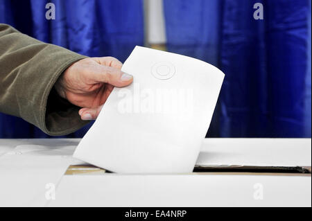 Close up de la main d'un homme mettant un vote dans l'urne Banque D'Images