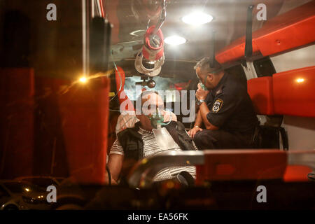 Jérusalem, Israël. Nov 6, 2014. Un policier israélien et un civil sont traités dans une ambulance près de l'endroit où une fuite d'ammoniac s'est produit à une usine de conditionnement dans la zone industrielle de Hefer Valley, le centre d'Israël, le 6 novembre, 2014. Un pompier est mort et au moins 16 personnes ont été blessées dans l'accident survenu jeudi soir, ont déclaré à Xinhua. © JINI/Nimrod Glikman/Xinhua/Alamy Live News Banque D'Images