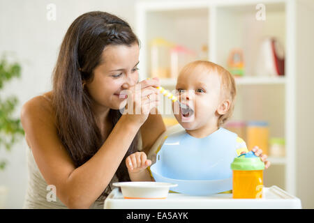 Belle jeune femme nourrit enfant garçon Banque D'Images