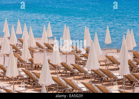 France, Côte d'Azur, Cannes, chaises longues et parasols sur la plage Banque D'Images