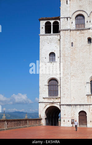 Homme marchant à l'extérieur de Palais des Consuls dans la Piazza Grande, Gubbio, Ombrie, Italie Banque D'Images