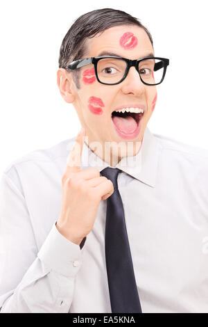 Heureux guy montrant le rouge à lèvres kiss marques sur son visage isolé sur fond blanc Banque D'Images