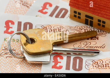 Clés maison sur l'anglais argent livre sterling dix livres de notes GBP Pour illustrer le concept d'économie sur les prix d'investissement de l'impôt foncier britannique dans Angleterre Royaume-Uni Grande-Bretagne Banque D'Images