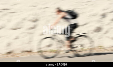 Blurred motion de man riding a bicycle Banque D'Images