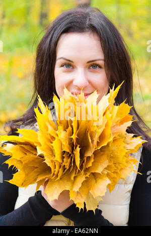 Brunette avec bouquet de feuilles Banque D'Images