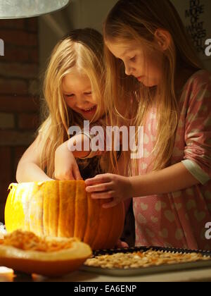 Deux filles préparant une citrouille pour Halloween, Suède Banque D'Images